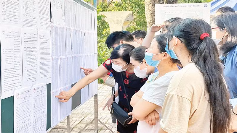 Cha mẹ và học sinh tìm hiểu thông tin nhập học lớp 10 tại Trường trung học phổ thông Yên Hòa. (Ảnh NGUYỄN HOÀI)