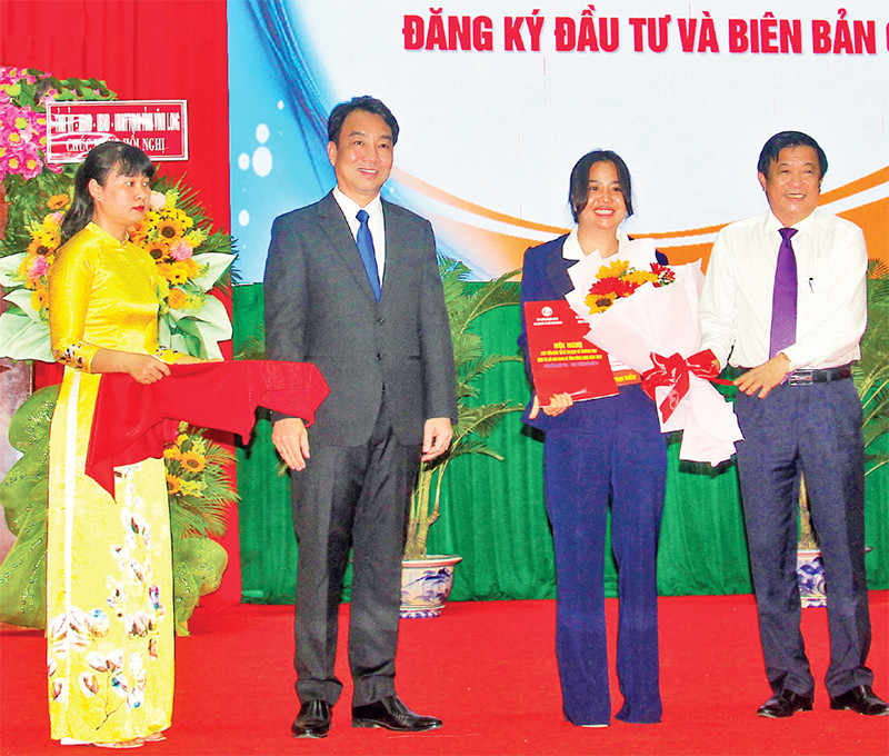 Lãnh đạo tỉnh Vĩnh Long trao giấy chứng nhận cho các nhà đầu tư. (Ảnh BÁ DŨNG)