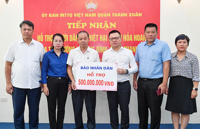Tổng Biên tập Lê Quốc Minh cùng đoàn Báo Nhân Dân trao 500 triệu đồng hỗ trợ các nạn nhân trong vụ cháy. (Ảnh THÀNH ĐẠT)