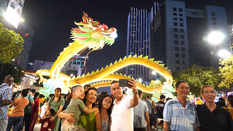 Người dân thích thú chụp ảnh tại Đường hoa Nguyễn Huệ. (Ảnh Thế Anh)