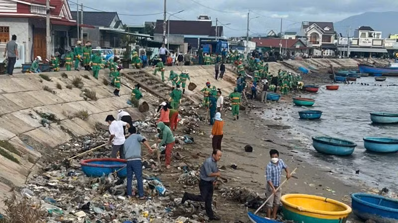 Thị trấn Khánh Hải, huyện Ninh Hải (Ninh Thuận) huy động hàng trăm cán bộ, nhân dân phối hợp với công nhân vệ sinh môi trường của Công ty Trách nhiệm hữu hạn Xây dựng-Thương mại và Sản xuất Nam Thành Ninh Thuận thu dọn hàng trăm khối rác tại khu vực đầm Nại. (Ảnh: NGUYỄN TRUNG)