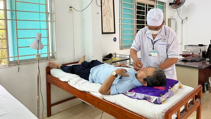 Y sĩ Nguyễn Hữu Đức điều trị cho bệnh nhân (Ảnh: NGUYỄN TRUNG)