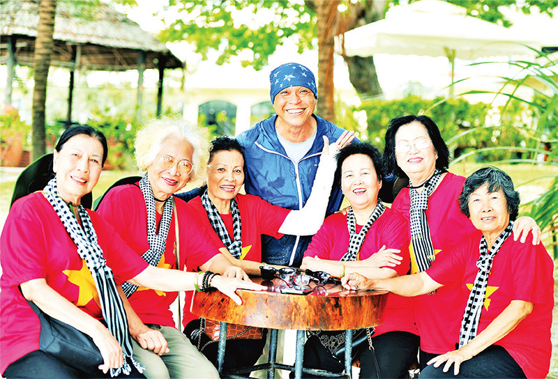 Nhiếp ảnh gia Nguyễn Á (áo xanh) chụp ảnh lưu niệm cùng các cựu tù Côn Đảo. (Ảnh CTV)