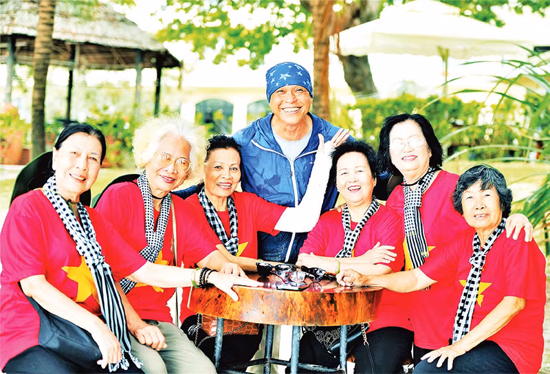 Nhiếp ảnh gia Nguyễn Á (áo xanh) chụp ảnh lưu niệm cùng các cựu tù Côn Đảo. (Ảnh CTV)