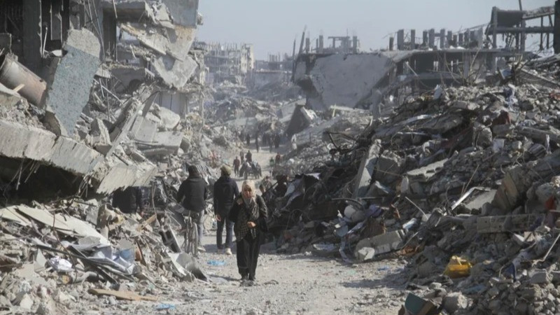 Người dân Palestine trên một con phố có những tòa nhà bị phá hủy tại trại tị nạn Jabalia ở phía bắc Dải Gaza, vào ngày 29/1/2025. (Ảnh: Tân Hoa xã)