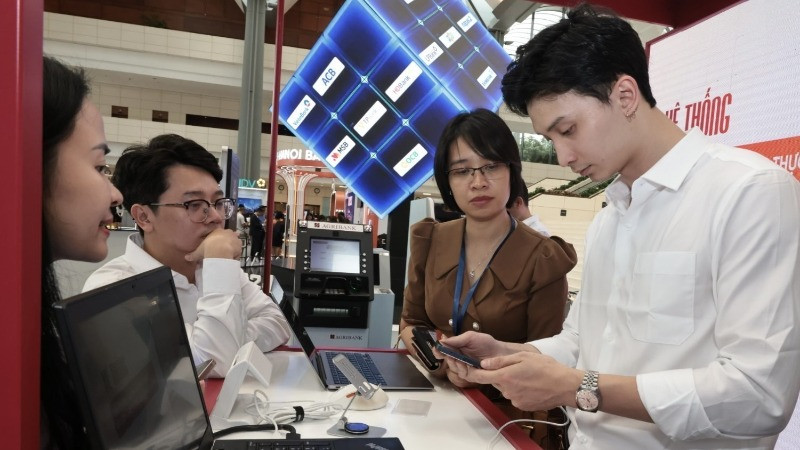 Hướng dẫn khách hàng sử dụng ngân hàng online tại Diễn đàn Chuyển đổi số ngành Ngân hàng năm 2024. (Ảnh TTXVN)