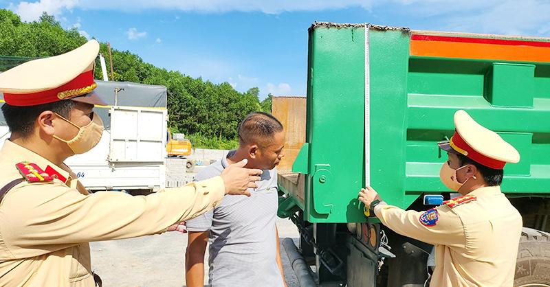 Lực lượng Cảnh sát giao thông Công an tỉnh Quảng Ninh xử phạt vi phạm và yêu cầu chủ phương tiện cắt bỏ thành thùng xe cơi nới không đúng quy định.