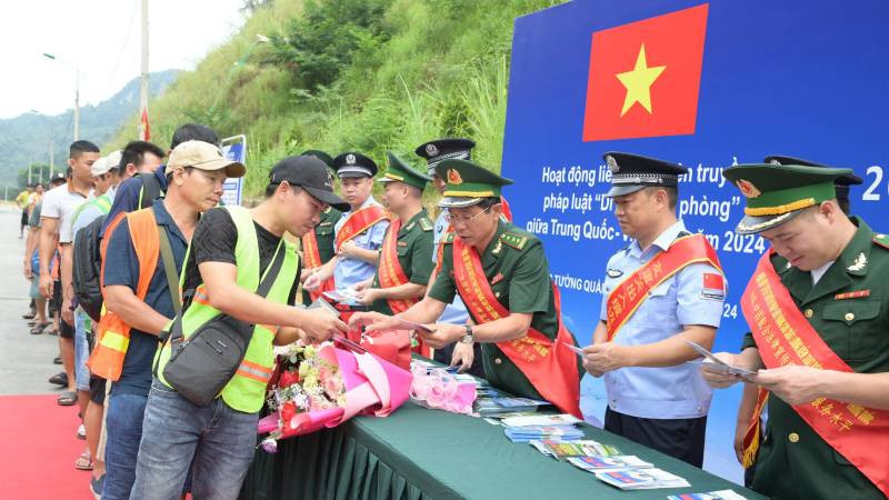 Cán bộ, chiến sĩ Đồn Biên phòng Tân Thanh, huyện Văn Lãng, Lạng Sơn (Việt Nam) và lực lượng chức năng Trạm Kiểm tra Biên phòng Pò Chài, Quảng Tây (Trung Quốc), phối hợp phát tờ rơi tuyên truyền pháp luật cho người dân qua lại biên giới. 