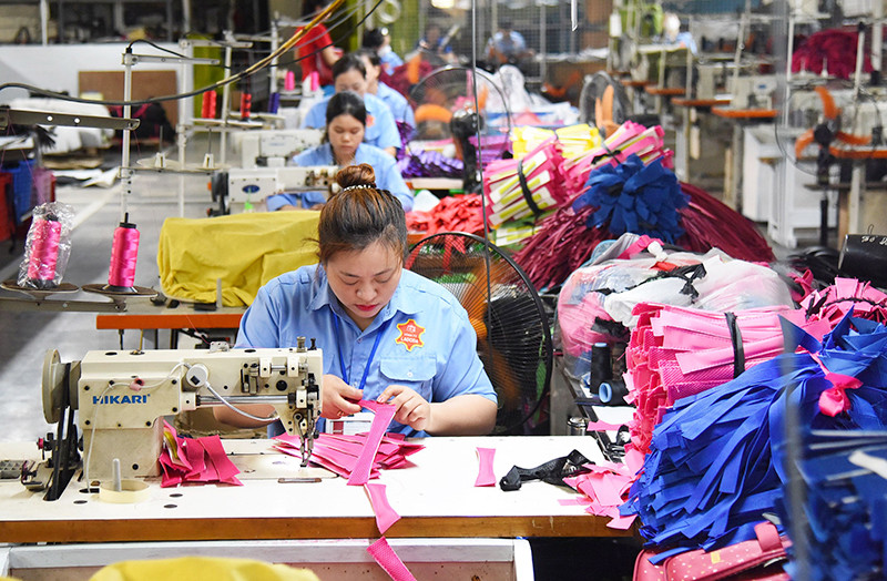 Công nhân Công ty LADODA may túi, cặp da. (Ảnh ĐỨC ANH)