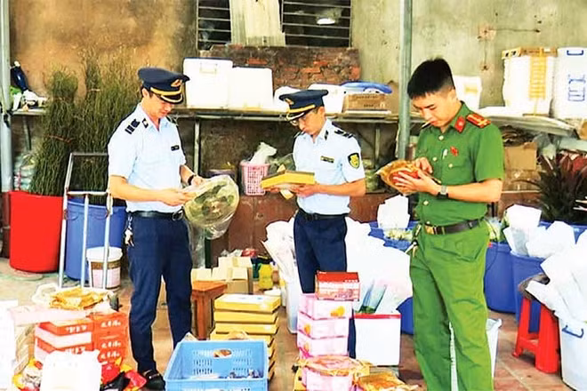 Lực lượng chức năng phát hiện, thu giữ bánh trung thu và một số thực phẩm nhập lậu tại hộ kinh doanh Lý Nguyễn Minh Châu. (Ảnh TRÍ DŨNG)