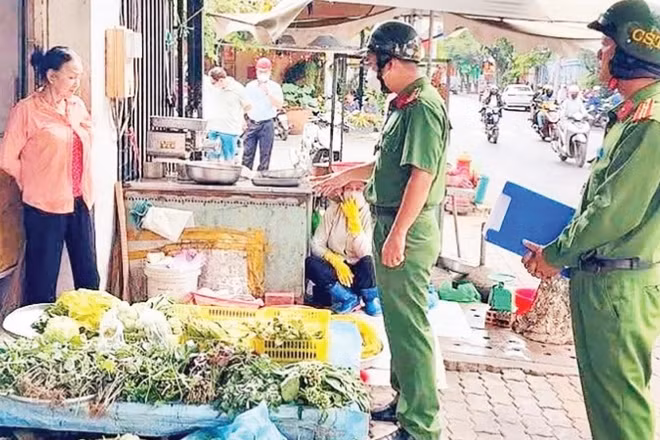 Công an phường Tân Hưng nhắc nhở người dân chấp hành trật tự vỉa hè khi buôn bán.