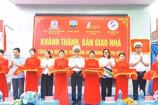 Các đại biểu và gia đình Mẹ Việt Nam Anh hùng Bùi Thị Bẻn cắt băng khánh thành nhà (Ảnh CTV)