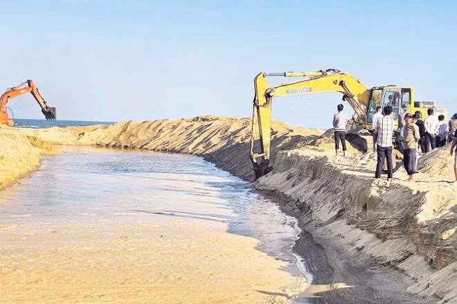 Xã Đông Trạch, tỉnh Quảng Trị huy động nhân lực, phương tiện đào cát lấp cửa sông Dinh lấy đường thủy cho ngư dân ra biển.