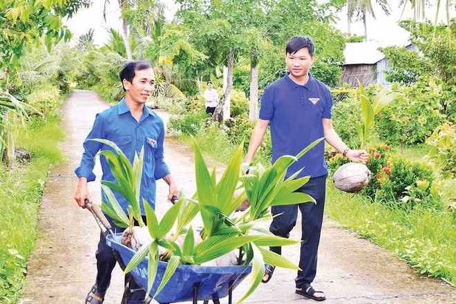 Anh Lê Trọng Đáng (bên trái), nguyên Bí thư Chi đoàn ấp Xẻo Lá B, xã Tân Thạnh với mô hình trồng dừa.