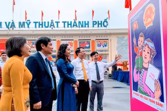 Các đại biểu xem tranh cổ động trưng bày tại triển lãm