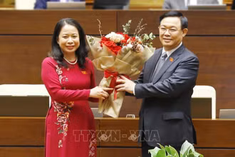 Chủ tịch QH Vương Đình Huệ trao hoa tặng Phó Chủ tịch nước Võ Thị Ánh Xuân. (Ảnh: TTXVN) 