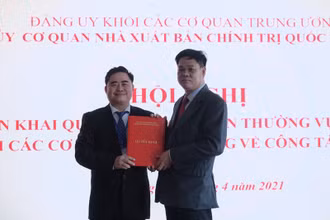 Đồng chí Huỳnh Tấn Việt (bên phải) trao Quyết định chuẩn y Bí thư Đảng ủy cơ quan NXB Chính trị quốc gia Sự thật cho đồng chí Phạm Minh Tuấn, Giám đốc, Tổng Biên tập NXB.