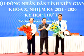 Thường trực HĐND tỉnh Kiên Giang tặng hoa cho ông Lê Quốc Anh (phải) và Nguyễn Đức Chín.