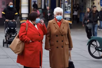 Người dân đeo khẩu trang chờ sang đường ở London, Anh, ngày 21/12/2021. (Ảnh: Reuters)