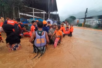 Nhân viên Lực lượng Bảo vệ bờ biển Philippines hỗ trợ sơ tán người dân rời khỏi khu vực bị ngập lụt do bão Rai tại thành phố Cagayan De Oro, ngày 16/12. (Ảnh: Reuters)