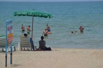 Du khách nước ngoài thư giãn trên bãi biển Patong ở Phuket. (Ảnh: Bưu điện Bangkok)