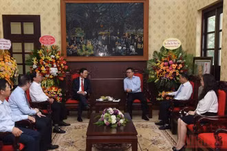 Bộ trưởng Thông tin và Truyền thông Nguyễn Mạnh Hùng chúc mừng lãnh đạo, cán bộ Báo Nhân Dân. (Ảnh: TRẦN HẢI)