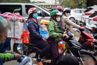 Em bé cũng theo bố mẹ cùng đồ đạc lỉnh kỉnh về quê ăn Tết. (Ảnh: Thành Đạt) 