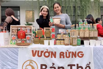 Ngọc Linh (bìa trái) giới thiệu sản phẩm của Vườn rừng Bản Thổ tại một phiên chợ nông nghiệp xanh.