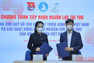 Bí thư Trung ương Đoàn, Chủ tịch Hội Sinh viên Việt Nam Nguyễn Minh Triết trao đổi biên bản cam kết tài trợ cho Quỹ Hỗ trợ và Phát triển sinh viên Việt Nam từ bà Lê Nữ Thùy Dương.