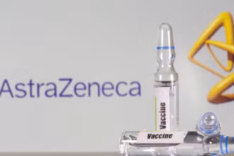 Một ống nghiệm có nhãn vaccine được nhìn thấy ở phía trước biểu tượng của AstraZeneca được chụp ngày 9-9. Ảnh: Reuters.