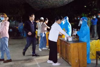 Các công dân nhận khẩu trang và làm thủ tục trước khi vào khu cách ly