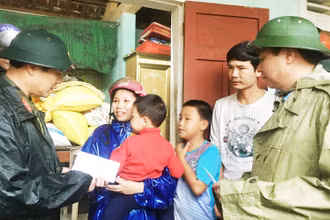 Thứ trưởng Quốc phòng Nguyễn Tân Cương (bên trái) cùng Chủ tịch UBND tỉnh Quảng Trị Võ Văn Hưng thăm, tặng quà cho hộ dân xã Triệu Thành, huyện Triệu Phong.