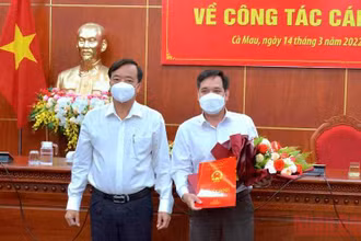Chủ tịch Ủy ban nhân dân tỉnh Cà Mau (bìa trái) trao quyết định và tặng hoa chúc mừng tân Chánh Văn phòng Ủy ban nhân dân tỉnh.