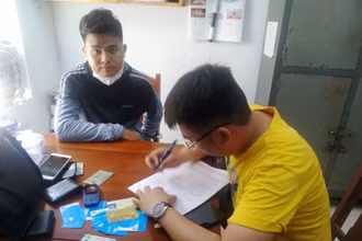 Đối tượng Nguyễn Bá Cường (áo xám) tại Cơ quan công an. (Ảnh: Công an cung cấp).