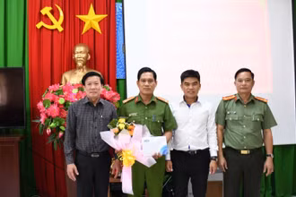 Đồng chí Nguyễn Văn Nhựt, Phó Giám đốc Ngân hàng Nhà nước Việt Nam chi nhánh Tiền Giang và đồng chí Nguyễn Hồng Khắc, Phó Giám đốc Công an Tiền Giang trao hoa, quà cho tập thể Công an TP Mỹ Tho.