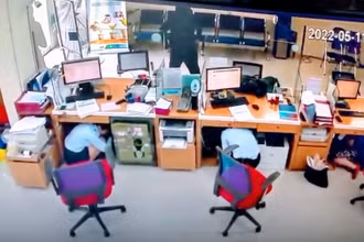 Hình ảnh tên cướp uy hiếp nhân viên ngân hàng định cướp tiền. (Ảnh cắt từ camera)