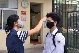 Đo thân nhiệt cho học sinh trước khi vào trường (Ảnh: THỦY NGUYÊN)