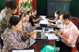 Cán bộ Ngân hàng Chính sách xã hội TP Hà Nội giúp người dân làm thủ tục vay vốn.