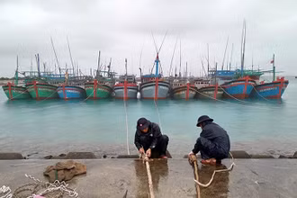 Cán bộ, nhân viên Trung tâm dịch vụ hậu cần - kỹ thuật đảo Sinh Tồn hỗ trợ ngư dân neo đậu tàu. Ảnh: ÐÌNH HOÀNG