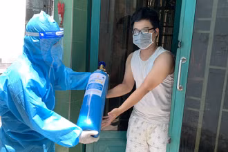 Trao bình oxy cho người nhà bệnh nhân điều trị cách ly tại nhà. 