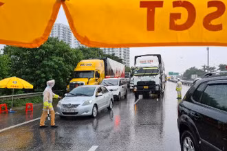 Cảnh sát giao thông làm việc dưới mưa tại Chốt kiểm dịch số 5, khu vực cầu Phù Đổng (Gia Lâm, Hà Nội).