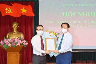 Đồng chí Nguyễn Trọng Nghĩa trao quyết định và tặng hoa, chúc mừng đồng chí Lê Quốc Minh. (Ảnh: Duy Linh)