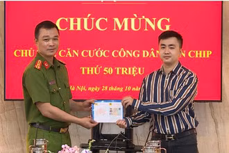 Thượng tá Tô Anh Dũng, Phó Cục trưởng Cảnh sát quản lý hành chính về trật tự xã hội tặng chiếc thẻ thứ 50 triệu cho công dân Trần Quang Huy.