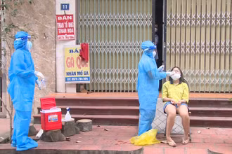 Cán bộ y tế lấy mẫu xét nghiệm cho F0 điều trị tại nhà.