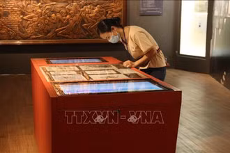 Khách tham quan trải nghiệm công nghệ tra cứu thông tin tại Bảo tàng phụ nữ Nam Bộ. Ảnh: TTXVN.