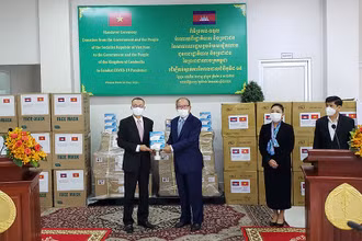Đại sứ Vũ Quang Minh bàn giao hàng viện trợ cho Bộ trưởng Y tế Campuchia Mam Bunheng.