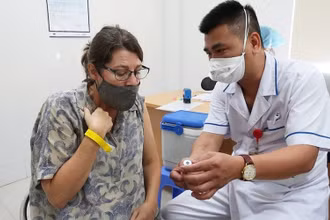 Nhân viên y tế cung cấp thông tin vaccine cho một cán bộ của tổ chức Phi chính phủ nước ngoài tại buổi tiêm ngày 13/7 (Ảnh: BV Phổi T.Ư). 