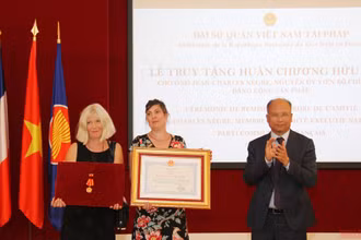 Đại sứ Đinh Toàn Thắng trao tặng Huân chương Hữu nghị cho vợ và con gái đồng chí Jean-Charles Nègre. (Ảnh: KHẢI HOÀN - ĐÌNH TUẤN).