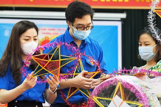 Các tình nguyện viên làm đèn ông sao tặng các em thiếu nhi tại Trung tâm Nuôi dưỡng người già và trẻ tàn tật Hà Nội.