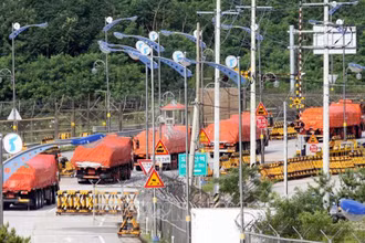Đoàn xe tải của Hàn Quốc vận chuyển gạo viện trợ cho Triều Tiên di chuyển qua khu vực phi quân sự ở Paju, phía bắc Seoul. (Ảnh (tư liệu): AFP/TTXVN)